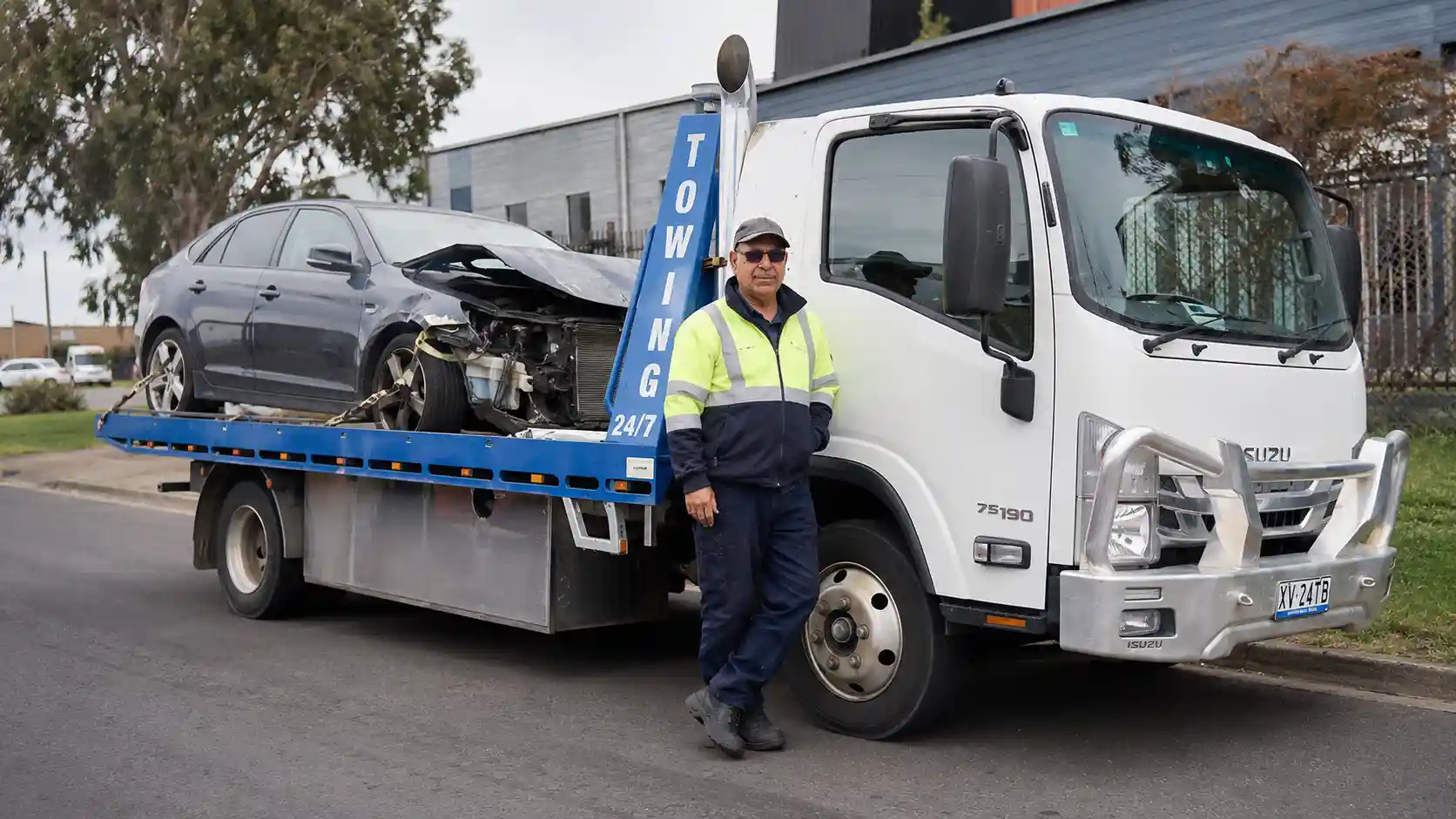 A Cash2Tow white flatbed tow truck loading a scrap Ute near the Princes Freeway to determine its scrap car value in Melbourne.